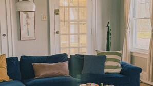 Un salon avec un canapé bleu, une table basse en bois et un tapis aux couleurs vives.