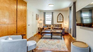 A cozy living room with a brown leather sofa, two armchairs, a coffee table, and a patterned rug. - Cozy 1-bedroom cottage in serene Fiddletown (Fiddletown)