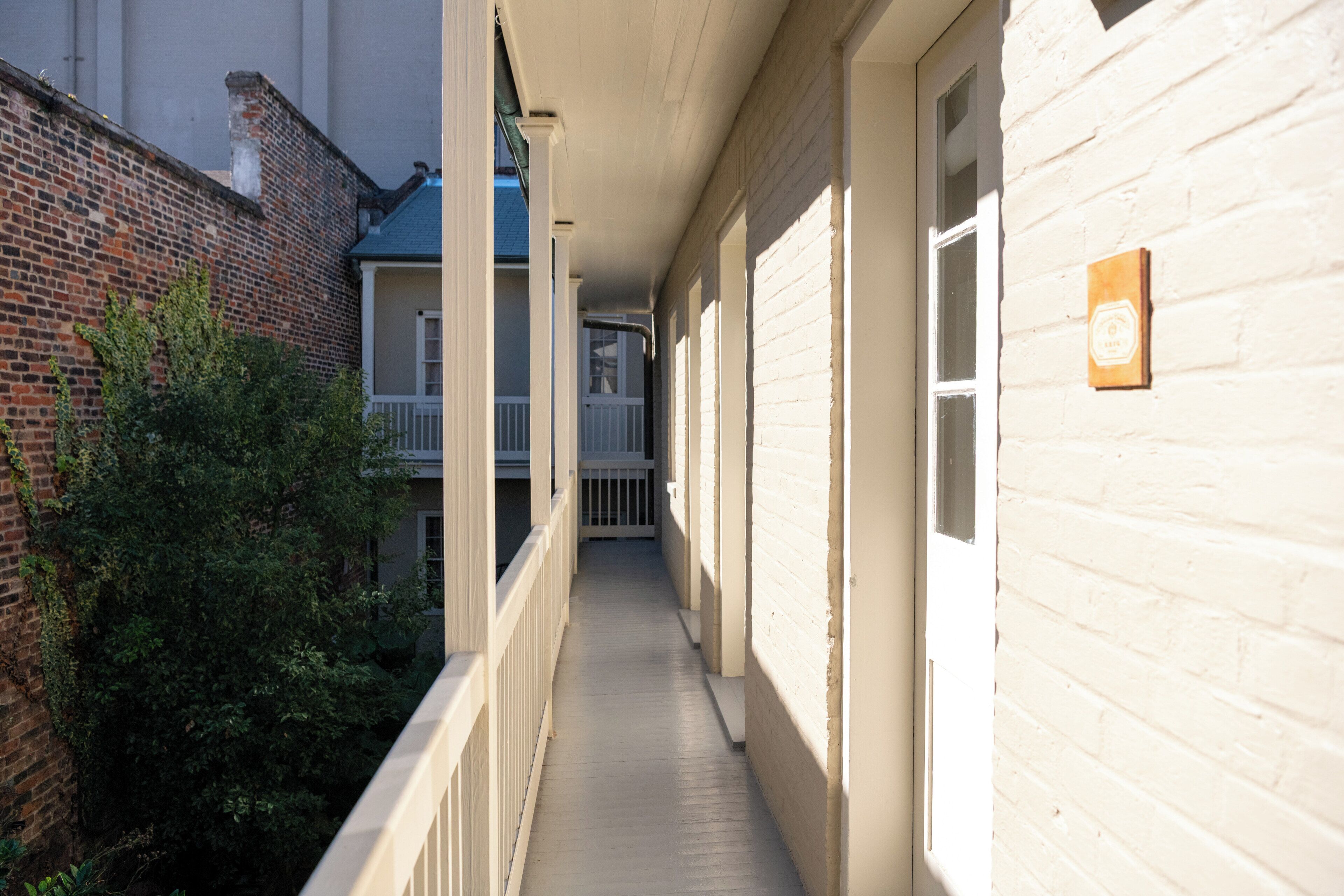 A narrow corridor with white-painted walls and a brick exterior.