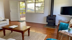 A living room with a fireplace, a sofa, a coffee table, and a television. - Lookin Good is a short walk to Inyadda Beach (Manyana)