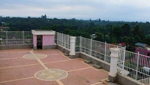 A rooftop terrace with a tiled floor, a small pink structure, and a white railing. - Paradise Apartments Embu (Embu)