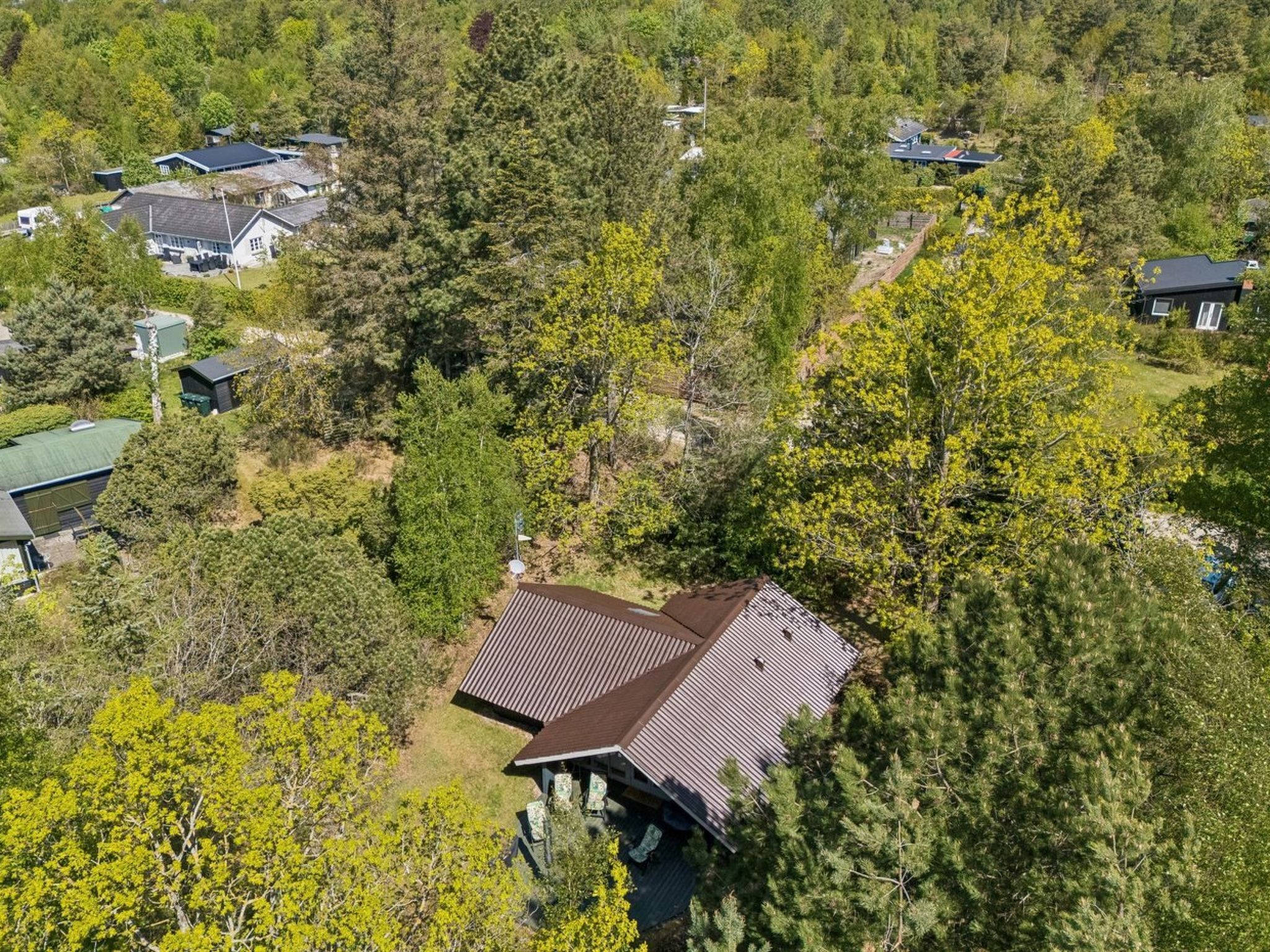 Vue aérienne d’un quartier résidentiel composé de nombreuses maisons, entourées d’une végétation dense.