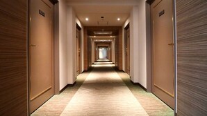 A hotel hallway with carpeted floors and wooden doors. - HOTEL CUORE TSURUGA (Tsuruga)