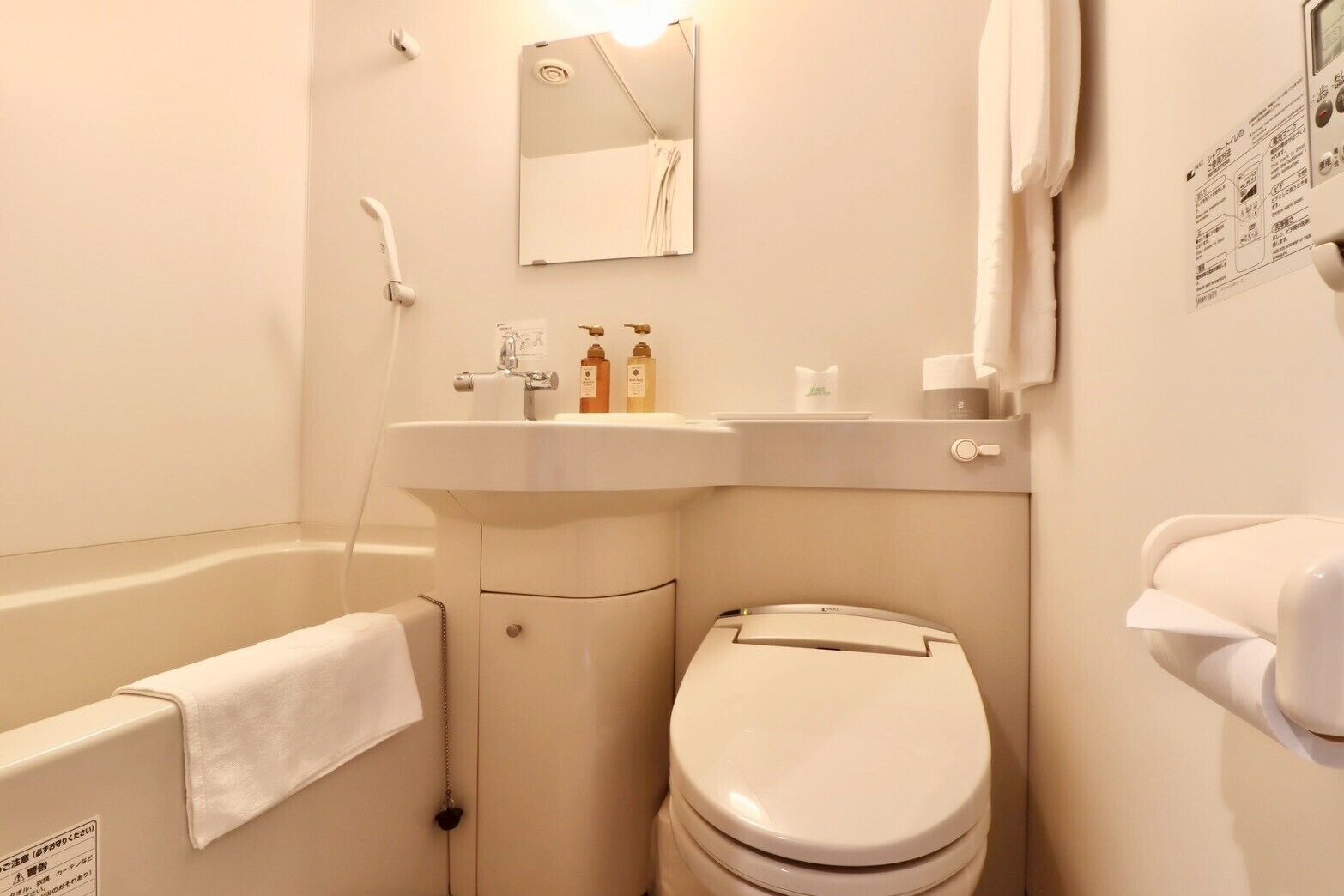 A bathroom with a bathtub, toilet, sink, and mirror.