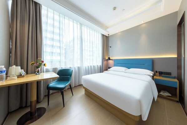 A hotel room with a bed, a desk, a chair, a nightstand, and a window with curtains. - Trendy Romantic Hotel Guangzhou Beijing Road Pedestrian Street Haizhu Square Metro Station Branch (Guangzhou)