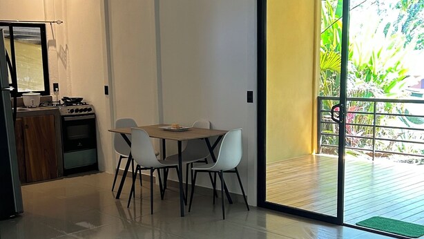 Una cucina moderna con piano cottura a gas, forno e zona pranzo con tavolo e sedie.