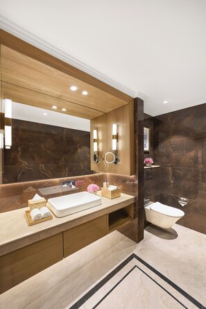 A modern bathroom with a large mirror, a bathtub, and a vanity with a sink. - Eternity IHCL SeleQtions (Kanpur)
