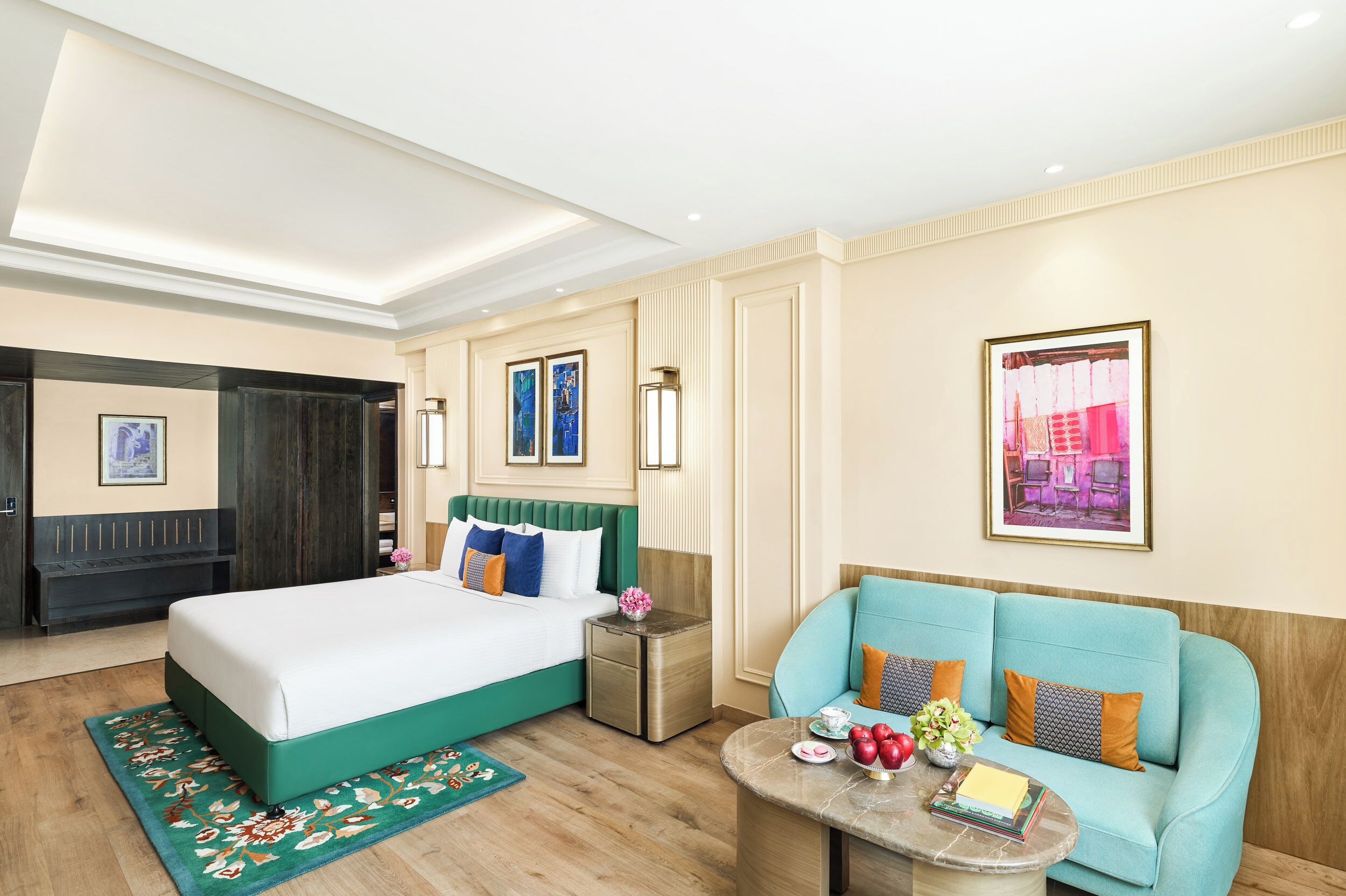 Una habitación de hotel con cama, sofá, una mesita y una mesilla de noche.