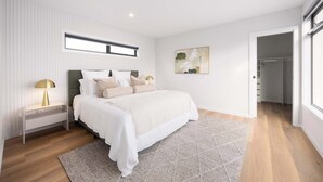 A bedroom with a bed, bedside tables, a window, a painting, and a closet. - Rooftop Deck & Sauna, 350m to Safety Beach (Safety Beach)
