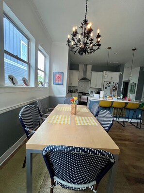 Un comedor con una mesa de madera, manteles individuales a cuadros y sillas con estampado.
