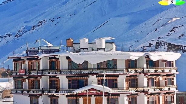 A multi-story building with traditional architecture, featuring balconies and a restaurant sign.