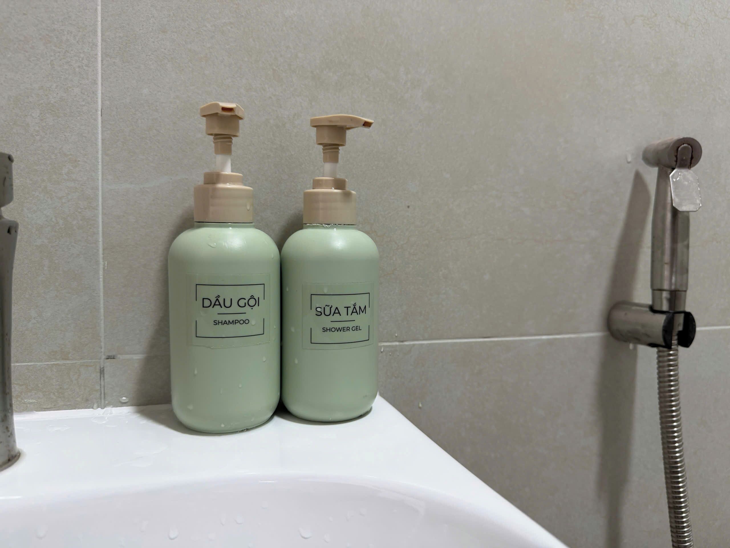 Two bottles of Dâu Gôi shampoo and Sửa Tám shower gel on a bathroom sink.