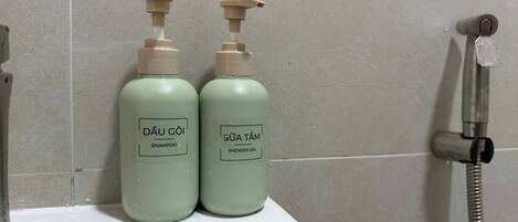 Two bottles of Dâu Gôi shampoo and Sửa Tám shower gel on a bathroom sink.