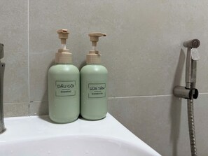 Zwei Flaschen Dâu Gôi Shampoo und Sửa Tám Duschgel auf einem Waschbecken.