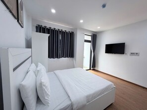 A hotel room with a bed, a wardrobe, a television, and a sign indicating WiFi availability. - Convinia Airport (Ho Chi Minh City)
