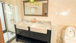 A bathroom with a double sink vanity, a shower, and a toilet. - Gio Hotel in Hue (Hue)