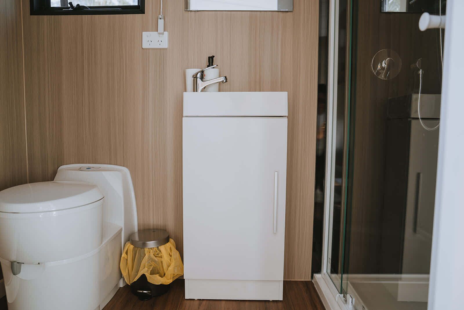 Un baño pequeño con inodoro, lavabo y zona de ducha.