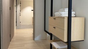 A modern bathroom with a wooden vanity, a mirror, and neatly folded towels.
