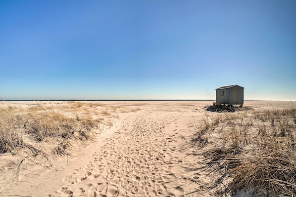 A sandy beach with a small, single-story building. - Steps to Brigantine Beach: New Jersey Beach Condo (Brigantine)