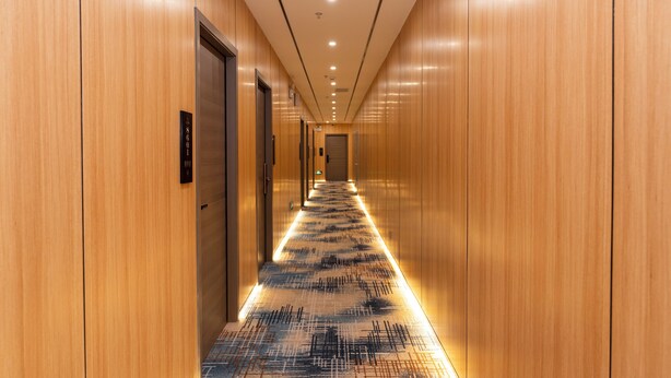 A long, narrow hallway with wooden walls and a patterned carpet. - Aura Crane Hotel Shenzhen Nanshan Xili Metro Station Branch (Shenzhen)