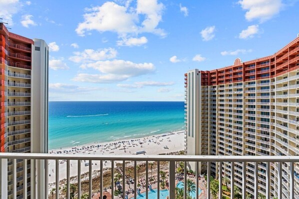Un hotel moderno con balcones que dan a una playa y al océano.