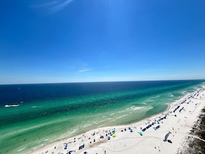 A beach with clear turquoise waters, a sandy shore, and beach umbrellas. - 2.5b3ba Gulf Front | Pool, Hot Tub | Beach chairs! (Panama City Beach)