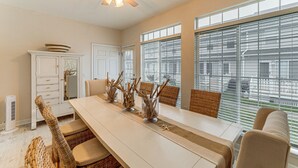 A dining area with a long table, wicker chairs, and a ceiling fan. - 2 Mi to Bethany Beach: Townhome w/ Pool Access! (Frankford)