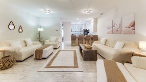 A spacious living room with a large sofa set, a coffee table, and a dining area with chairs. - 2 Mi to Bethany Beach: Townhome w/ Pool Access! (Frankford)