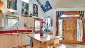 Une cuisine moderne avec des meubles en bois, un îlot central et une grande porte en bois.