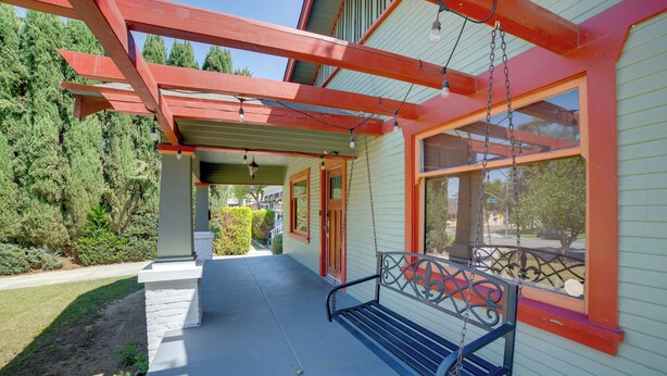 A porch with a swing, a covered area, and a house with large windows. - Home 1/2 Mi to Dtwn Riverside: Families Welcome! (Riverside)