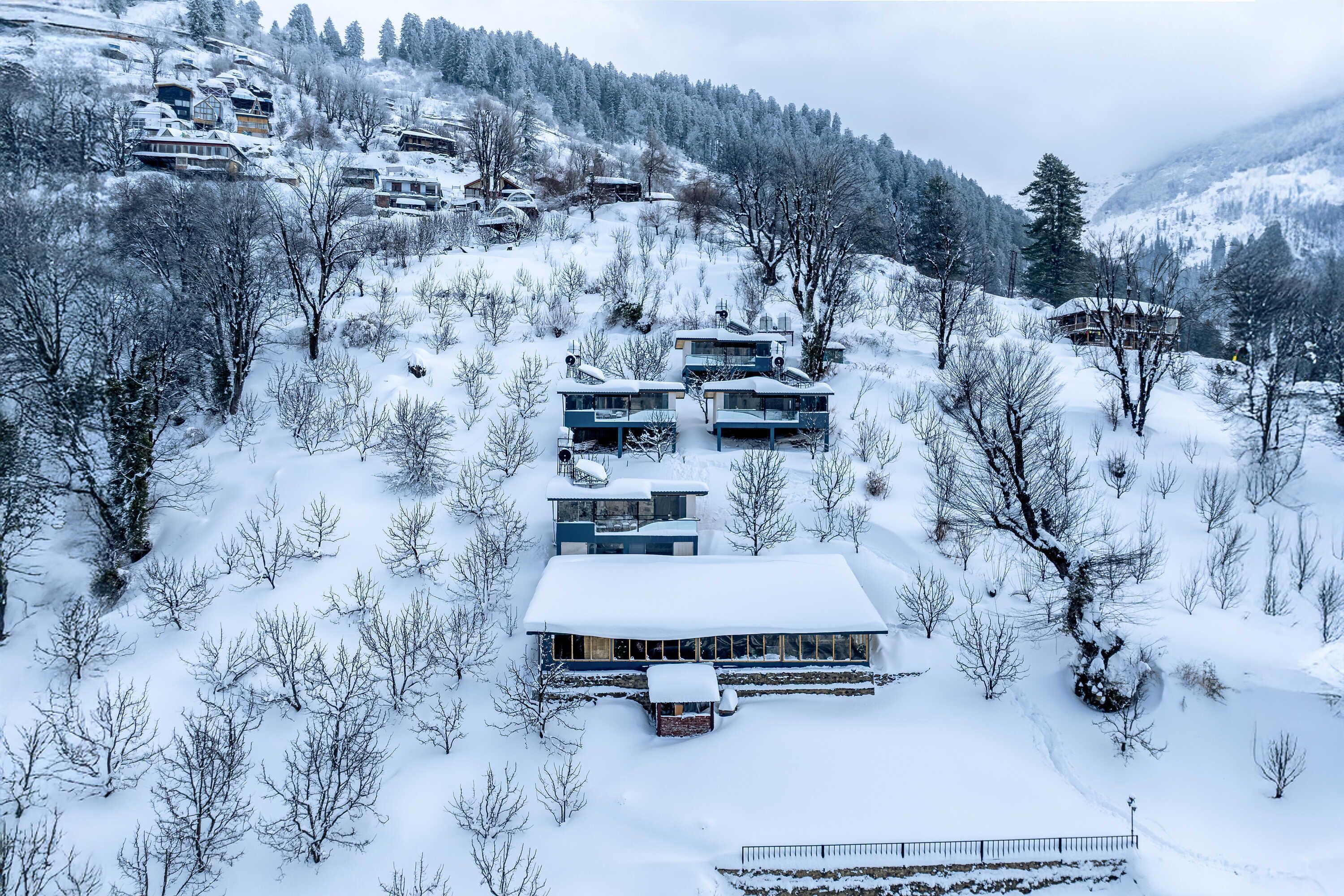 A modern ski resort with multiple chalet-style buildings nestled in a snowy mountainous area.