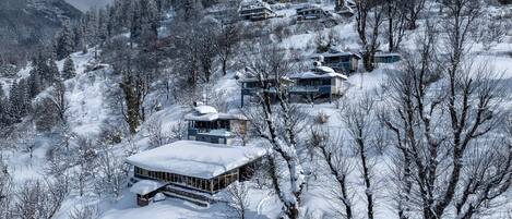 A snow-covered mountain village with multiple chalet-style buildings.
