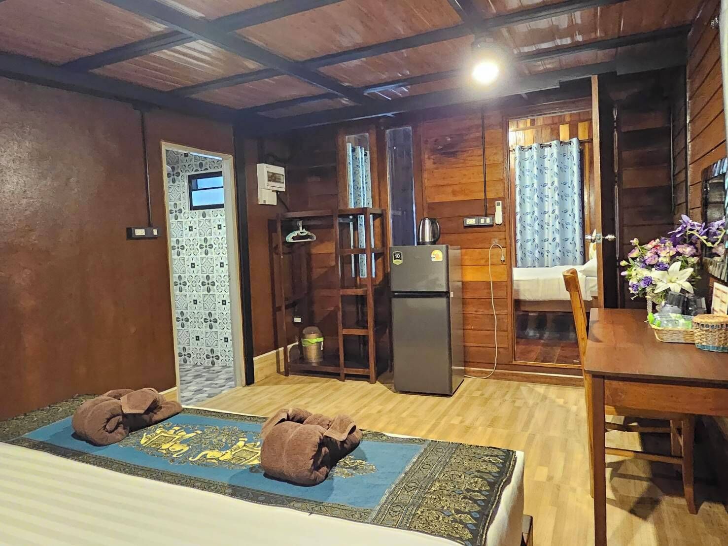 Una habitación acogedora con una cama, un pequeño kitchenette, una mesa de comedor y una silla.
