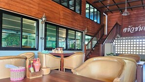 Un ristorante con arredi in legno, diversi tavoli e sedie.