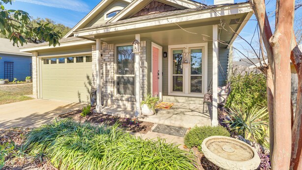 A residential house with a front porch, a garage, and a landscaped garden. - ATX Urban Oasis: Cowboy Pool + Fenced Yard (Austin)