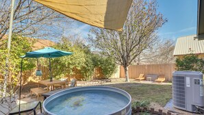 A backyard with a hot tub, outdoor furniture, and a wooden deck. - ATX Urban Oasis: Cowboy Pool + Fenced Yard (Austin)