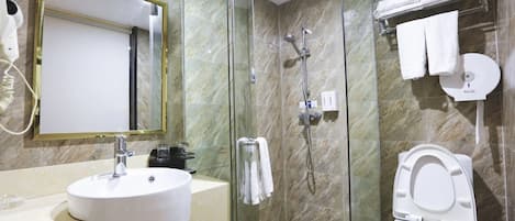 Un baño con lavabo, espejo, ducha e inodoro.