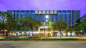 A modern hotel with a prominent sign, surrounded by trees and a well-lit street. - AeroLink Hotel Shenzhen Bao'an Airport  (Shenzhen)