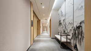 A hallway with a bench, a mural, and a staircase. - AeroLink Hotel Shenzhen Bao'an Airport  (Shenzhen)