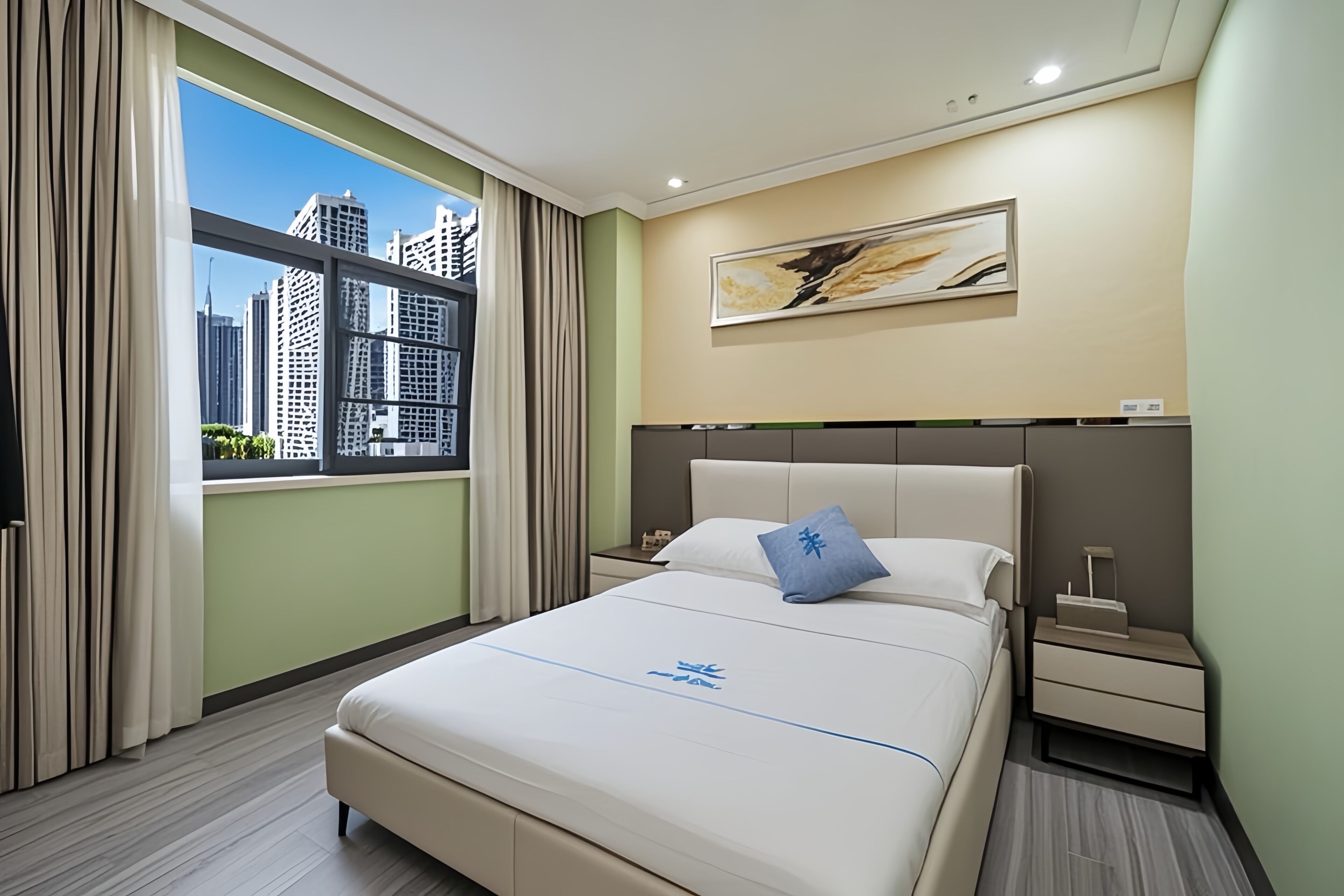 Ein Hotelzimmer mit einem großen Bett, einem Nachttisch, einem Fenster mit Vorhängen und Blick auf die Stadt.