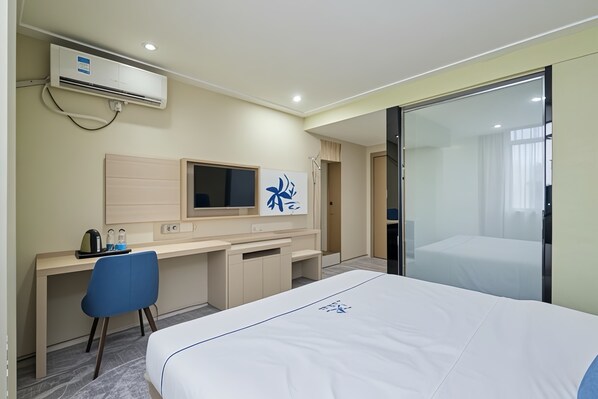 A hotel room with a bed, a desk, a chair, a TV, and a sliding door. - AeroLink Hotel Shenzhen Bao'an Airport (Shenzhen)