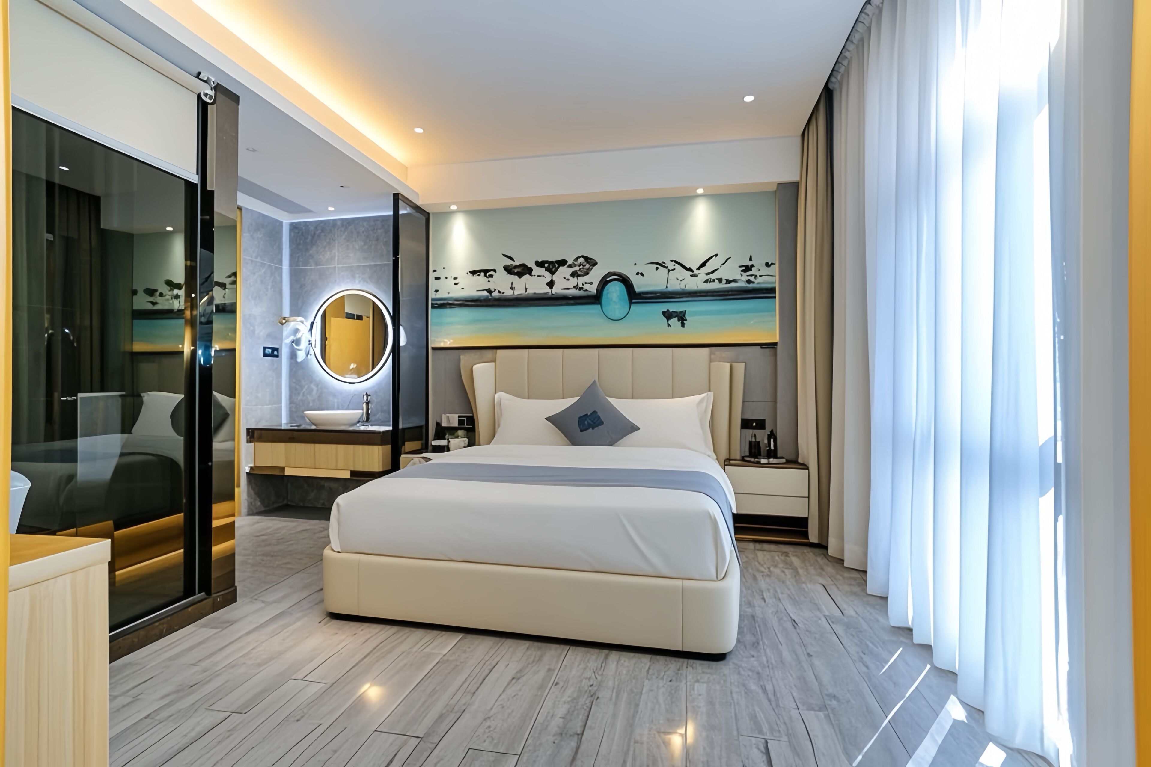Une chambre d’hôtel moderne dotée d’un grand lit, d’une salle de bain entièrement vitrée, d’un miroir rond et d’une fresque murale.