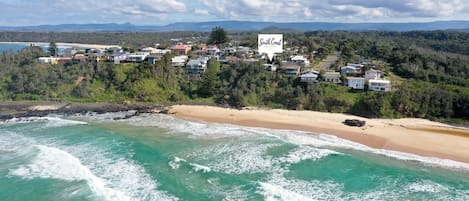 Zona residencial costera con casas con vistas a una playa y al océano.