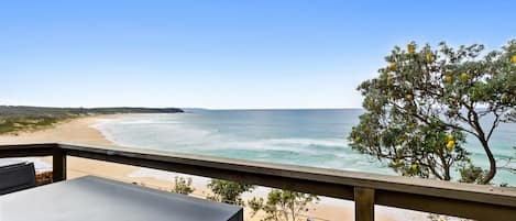A balcony with a view of a beach and ocean.
