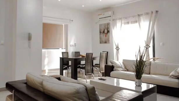 Un salon moderne comprenant un canapé, une table basse, une table à manger et des chaises.