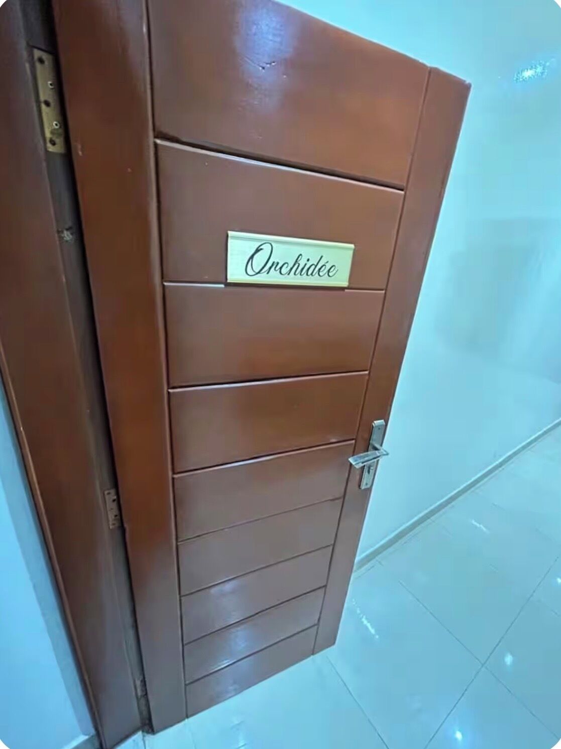A brown door with a nameplate reading "Orchidée."