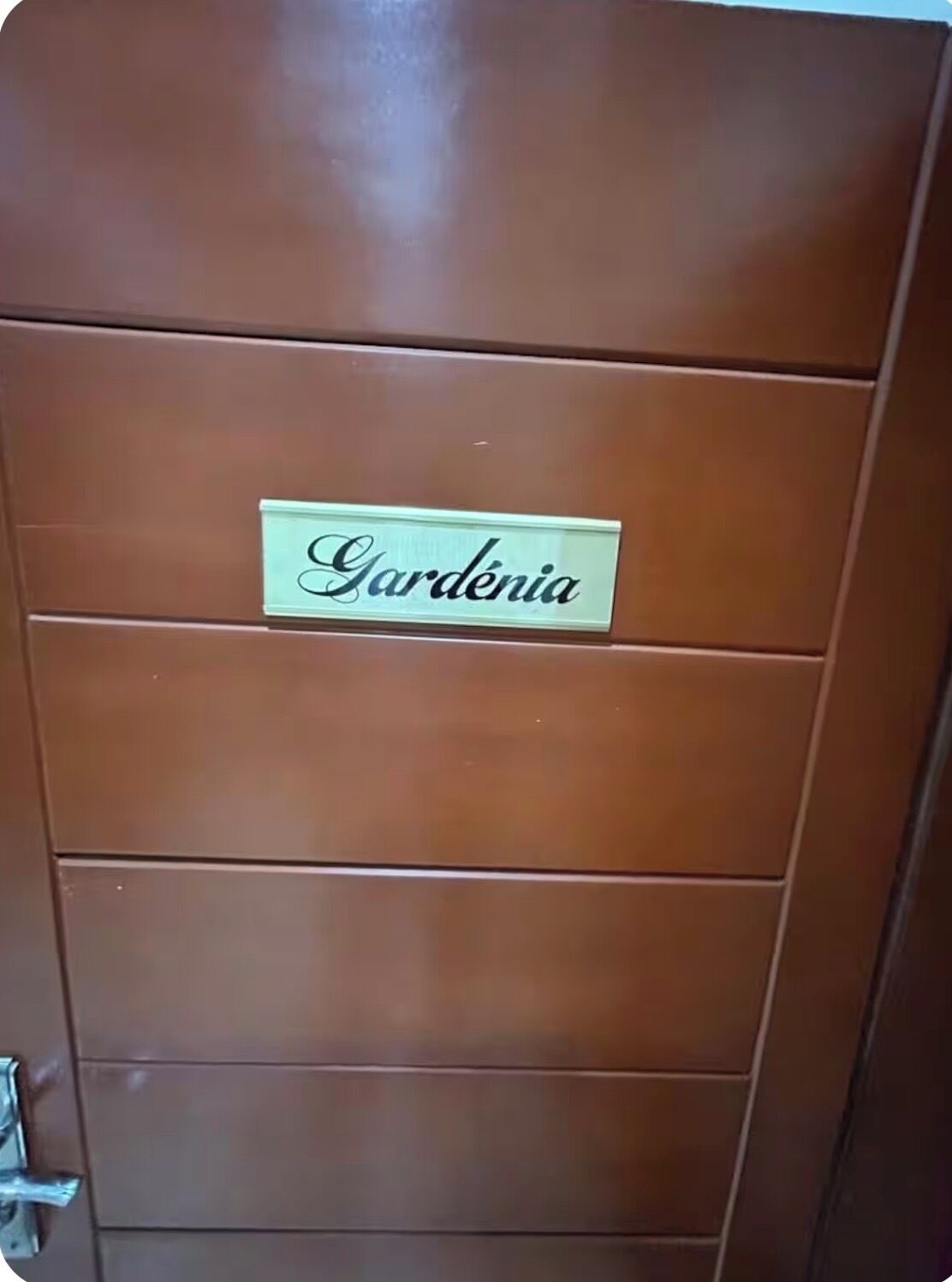 A brown door with a sign that reads "Gardénia".