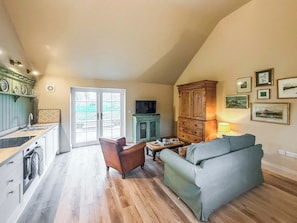Amplia sala de estar con un sofá, un mueble de madera y un televisor.