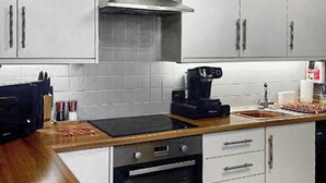 A kitchen with white cabinets, a stainless steel range hood, a coffee maker, and a toaster. - Merewyke Boutique Apartment - UK51055 (Bowness-on-Windermere)