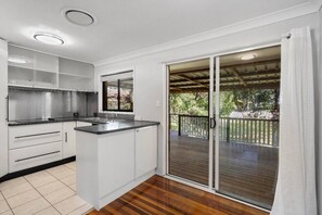 A kitchen with white cabinets, a countertop, and a window. - House with huge back yard and side access, 11 Beds (Riverview)